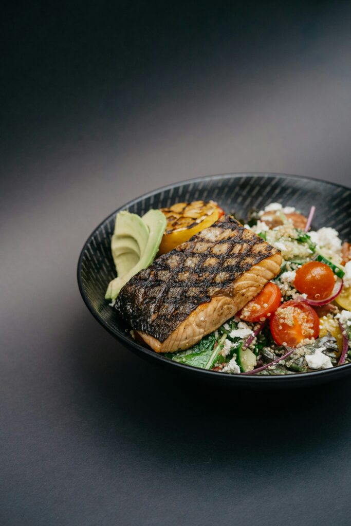 `grilled salmon bowl with avocado quinoa and vegetables for post-run recovery`