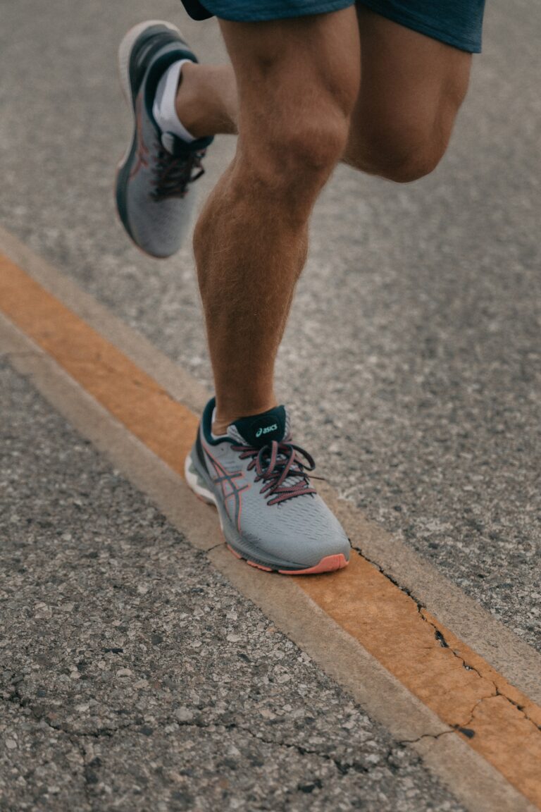 runner in ASICS running shoes training on asphalt road