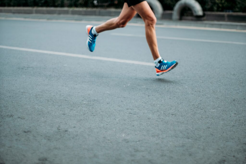 Runner in blue and orange Adidas shoes sprinting on asphalt road
Runner sprinting on asphalt road — half marathon race day fueling guide