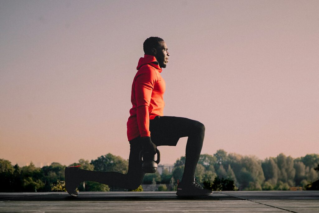 runner performing a kettlebell lunge outdoors
