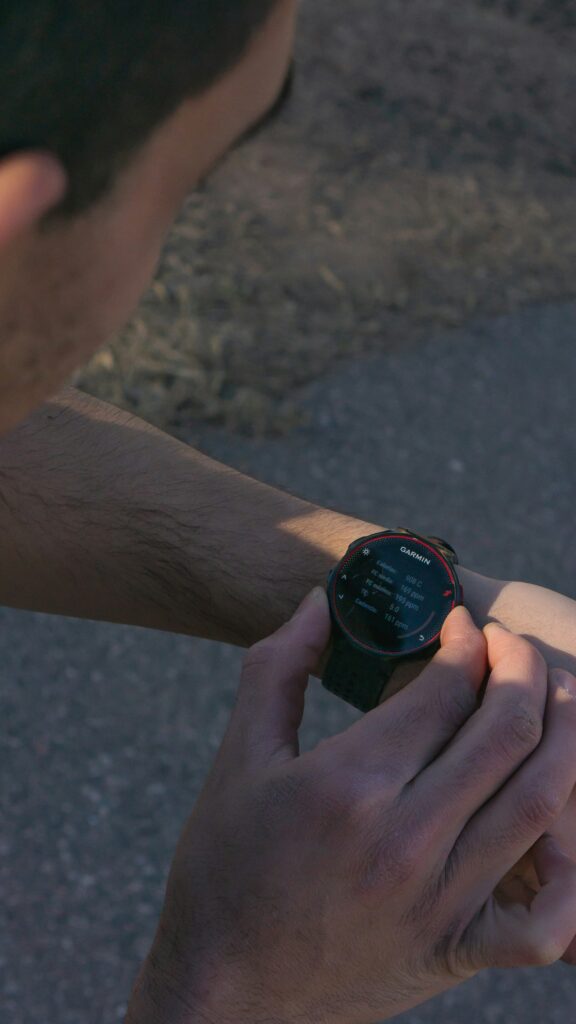 Current image: runner looking at GPS watch during outdoor training run