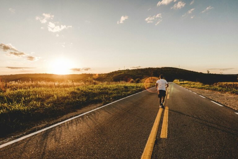 runner on an open road during an easy morning run at sunrise
