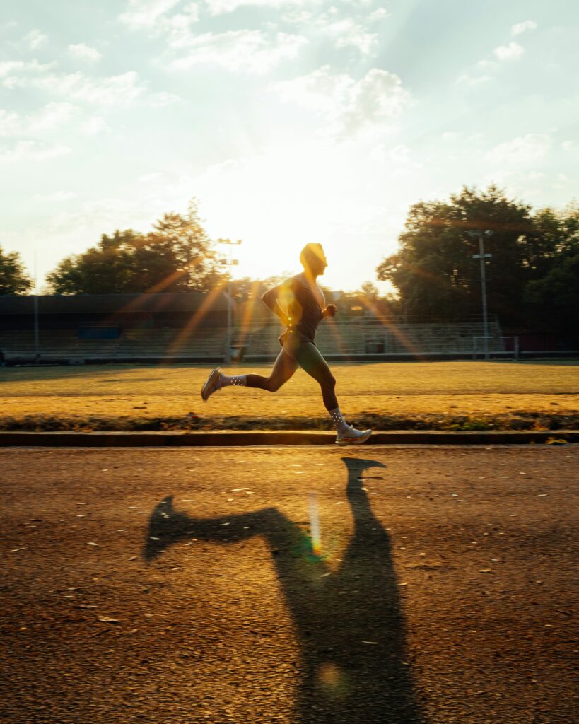 Current image: runner sprinting on athletics track at golden hour