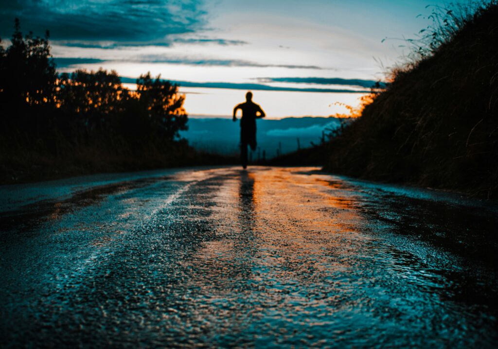 Current image: runner silhouette on a wet road at dawn training for weight loss