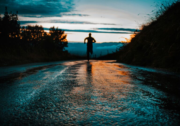 runner silhouette on a wet road at dawn training for weight loss